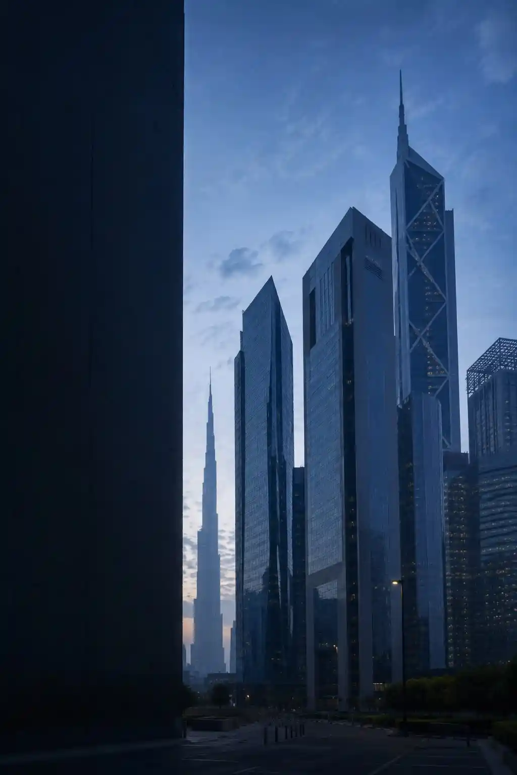 The Dubai skyline at blue hour, looking down a street in DIFC toward the Burj Khalifa